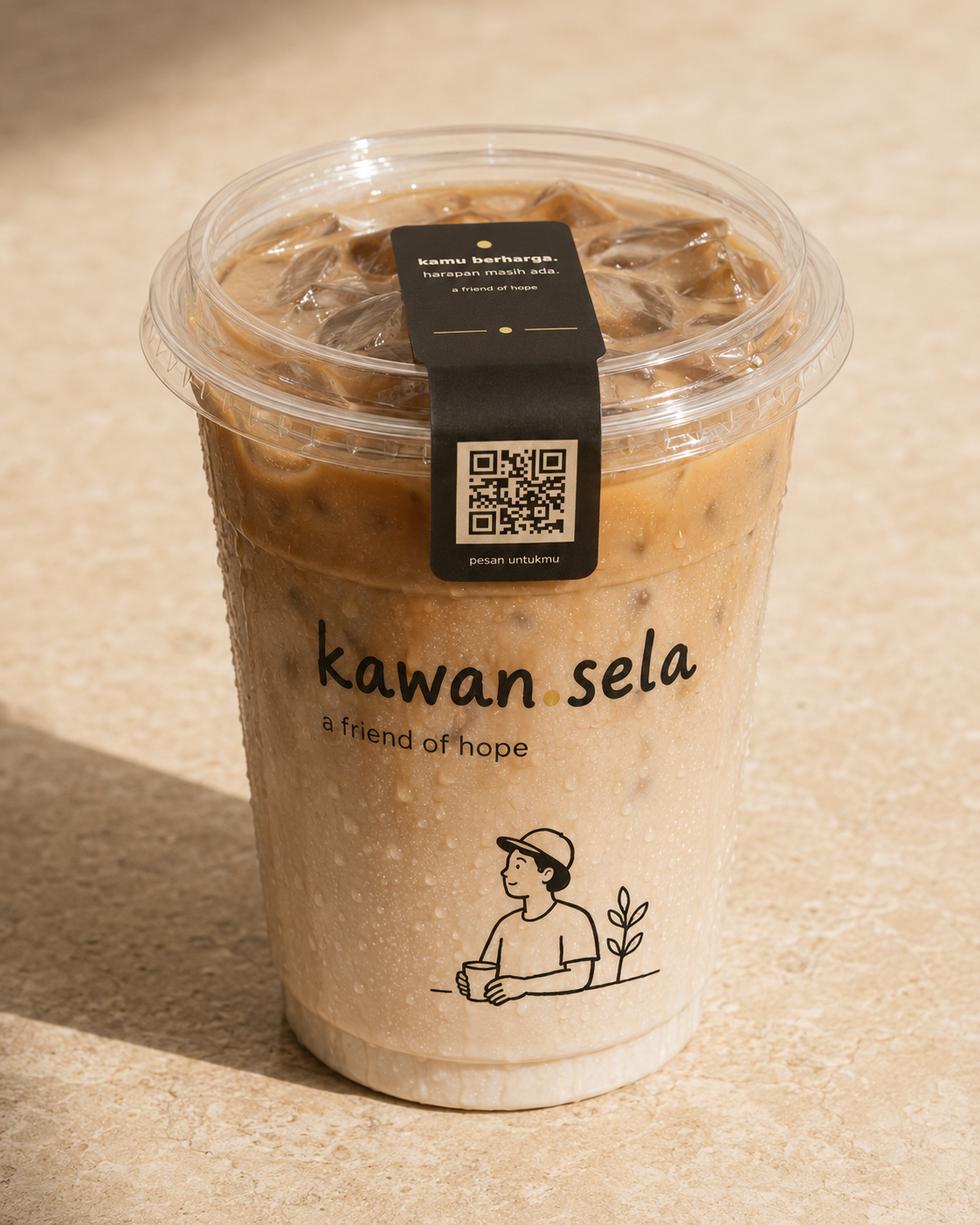 Es kopi kawan.sela dalam gelas bening 12 oz dengan es, lapisan kopi susu, embun, dan pesan harapan pada segel tutup